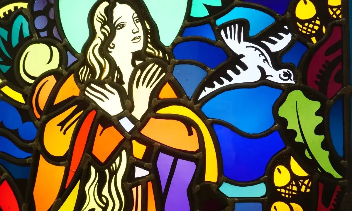 Vitrail coloré, une femme aux longs cheveux et un oiseau blanc en vol, dans le style de Jacques Gruber.