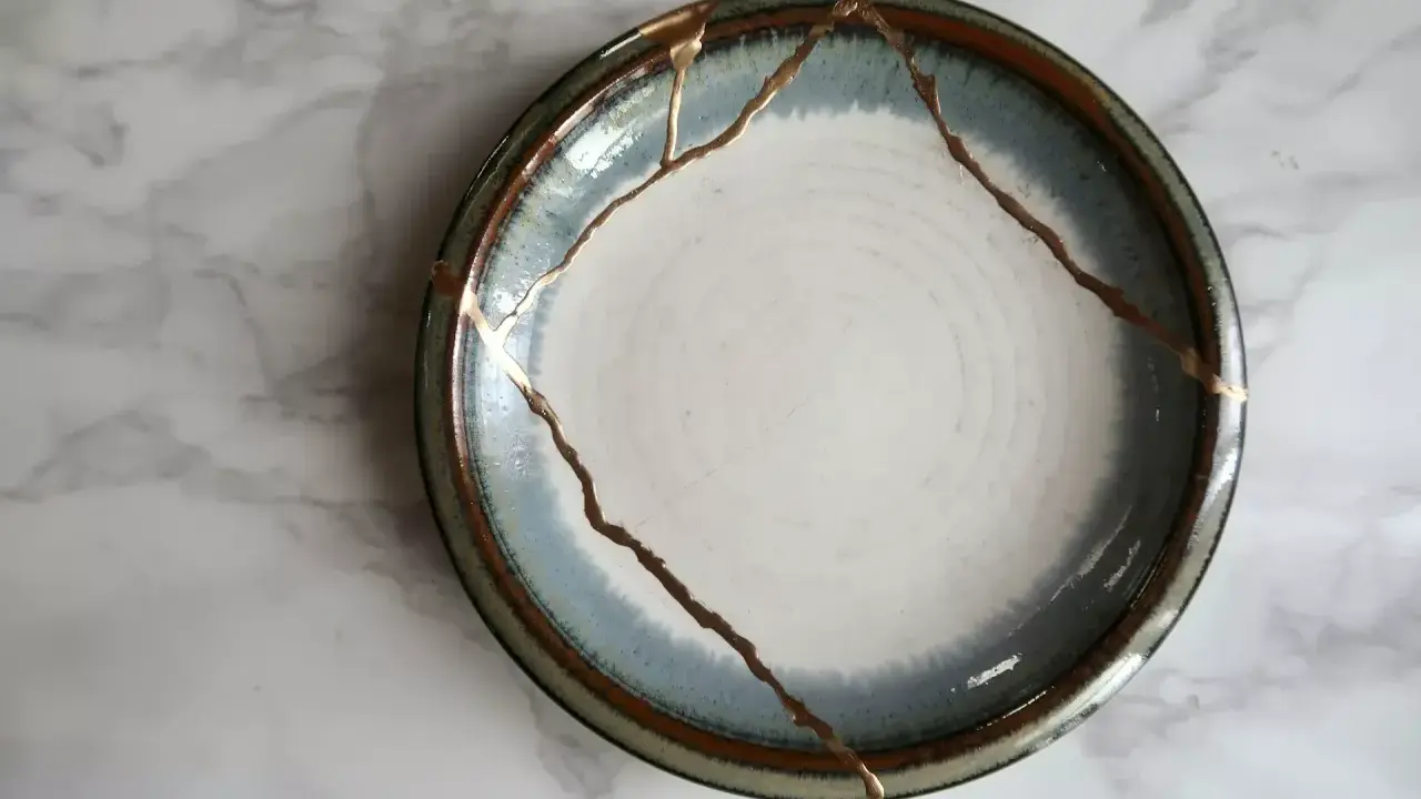 Une assiette ébréchée, réparée avec de l'or, témoigne de la beauté de la résilience.