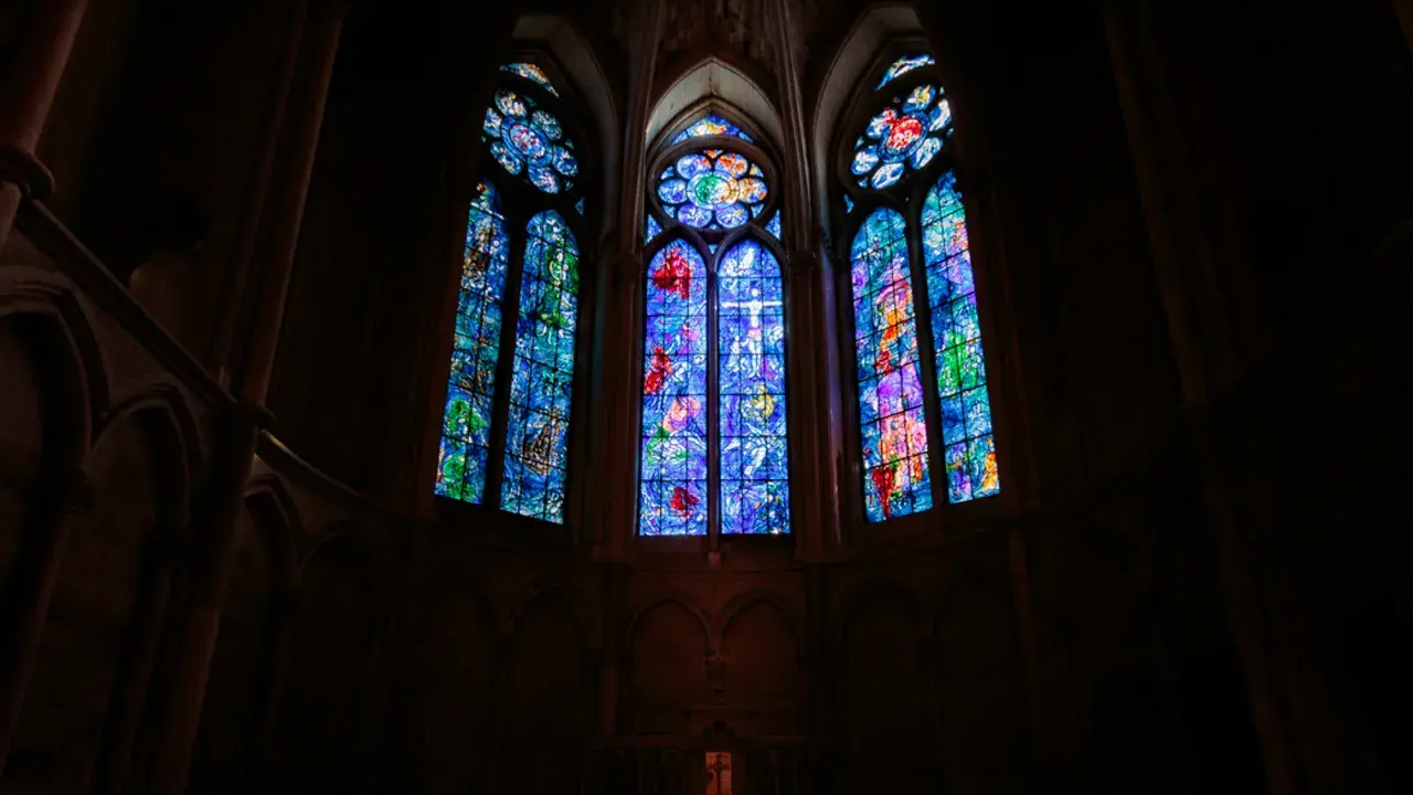 Vitraux de Chagall à Reims, illuminant l'intérieur sombre d'une cathédrale gothique.