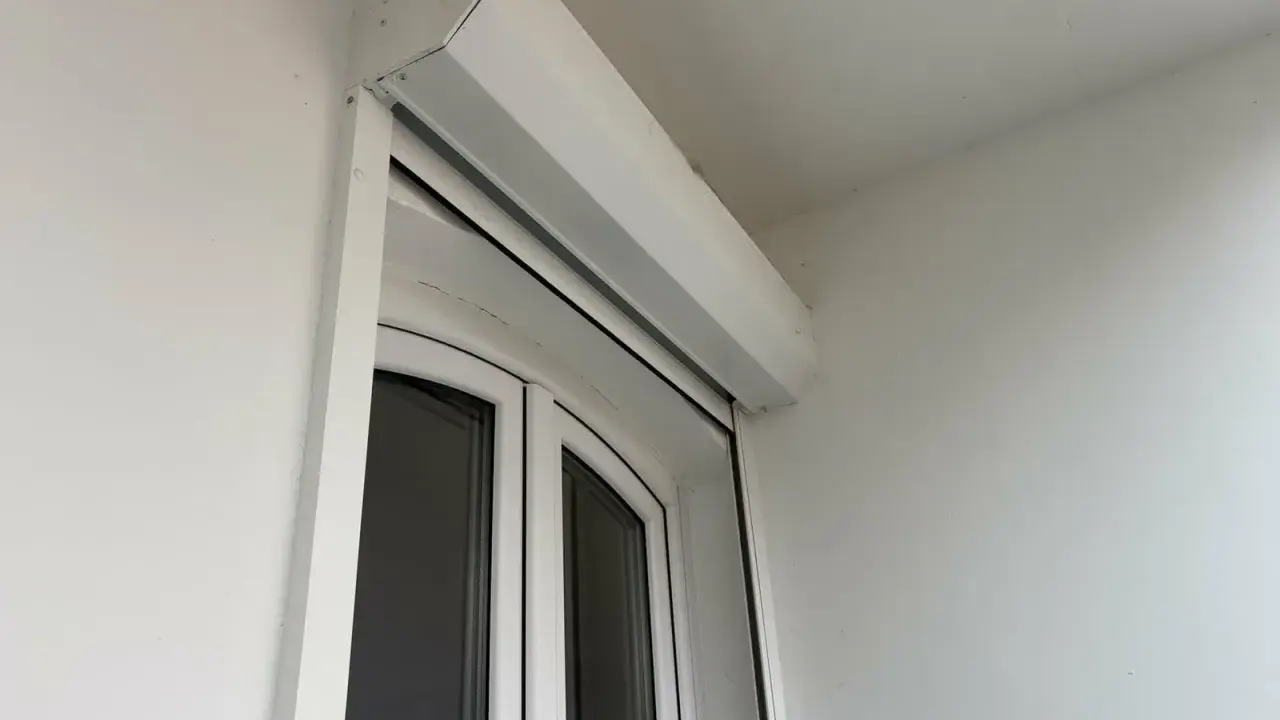 Un imposte blanc est installé au-dessus d'une porte-fenêtre blanche.