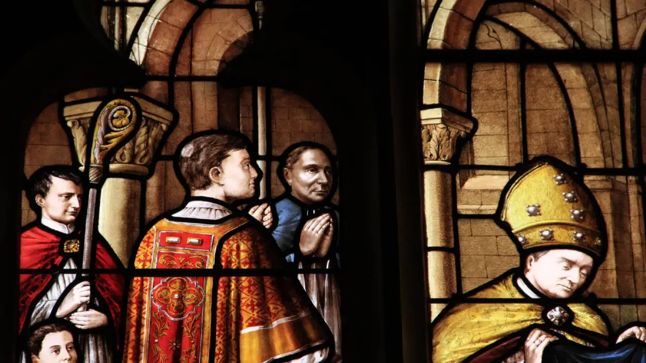 Vitraux de la cathédrale de Nevers : scènes religieuses avec des personnages en habits liturgiques, un évêque coiffé de sa mitre dorée.