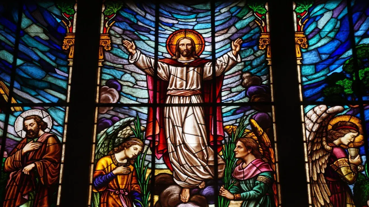 Magnifique vitrail d'église représentant le Christ entouré d'anges et de saints, baigné de lumière.