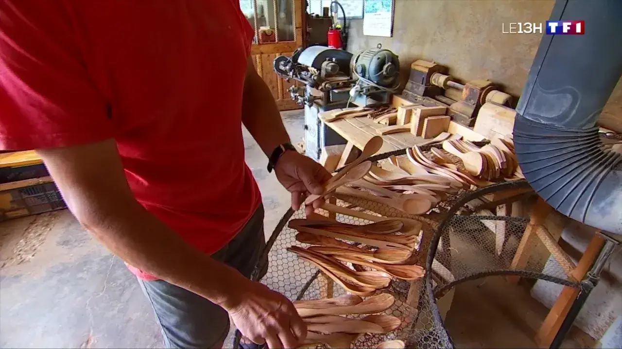 Un artisan du bois, maître dans son métier de tabletier, présente une collection de cuillères en bois faites à la main.