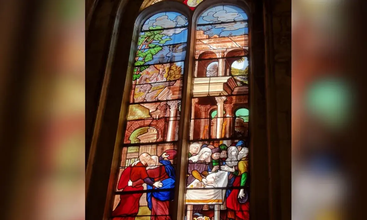 Magnifique **verre d'église** racontant des scènes bibliques, avec des personnages en habits d'époque et des paysages stylisés.