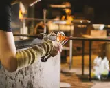 Souffleur de verre travaillant le verre en fusion, un métier qui mérite un bon salaire.