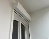 Un imposte blanc est installé au-dessus d'une porte-fenêtre blanche.