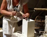 Un artisan tailleur de pierre travaille la pierre avec un marteau et un ciseau.