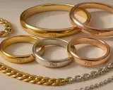 Comment reconnaître l'or 18 carats : des bagues et chaînes en or jaune, rose et argenté portent la marque "750", indiquant 75% d'or pur.
