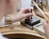 Un orfèvre au travail, façonnant une bague avec précision. Son métier d'orfèvre demande patience et dextérité.