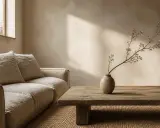 Un salon apaisant dans un style wabi sabi, avec un canapé en lin, une table basse en bois brut et une branche délicate dans un vase texturé.