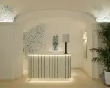 L'entrée art déco dévoile une réception lumineuse, ornée de fresques murales et d'une plante luxuriante.