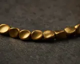 Un bracelet en cuivre aux perles dorées, parfait pour apprendre comment nettoyer un bracelet en cuivre et lui redonner son éclat.