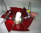 Un photophore vitrail aux couleurs vives, orné de deux anges aux ailes translucides, tenant une bougie blanche.