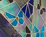 Un vitrail sur mesure aux couleurs vives, avec des motifs de papillons bleus et des éclats irisés.