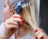 Application d'une patine sur des cheveux blonds. Le dosage précis est essentiel pour obtenir la teinte désirée.