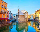 Canal pittoresque à Annecy, avec ses maisons colorées et le Palais de l'Isle. Idéal pour flâner et découvrir l'artisanat local.