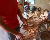 Un artisan du bois, maître dans son métier de tabletier, présente une collection de cuillères en bois faites à la main.