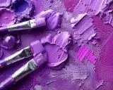 Pinceaux et peinture violette sur une palette. Découvrez comment faire du violet avec de la peinture pour vos créations artistiques.