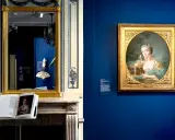 Portrait d'une jeune femme par un peintre français moderne, exposé dans un musée. Un livre ouvert sur une cheminée reflète l'œuvre.