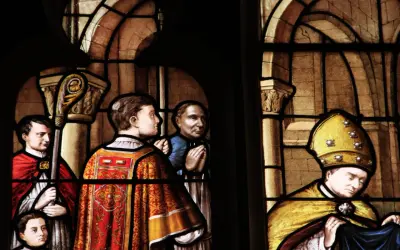 Vitraux de la cathédrale de Nevers : scènes religieuses avec des personnages en habits liturgiques, un évêque coiffé de sa mitre dorée.