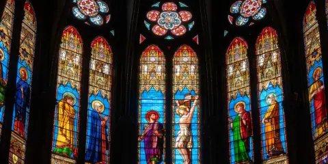 Magnifiques art vitraux d'une église, représentant des scènes bibliques avec des figures colorées sur fond bleu.