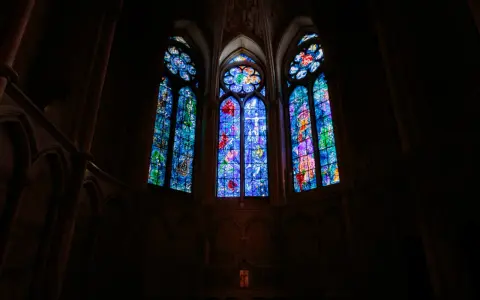 Vitraux de Chagall à Reims, illuminant l'intérieur sombre d'une cathédrale gothique.