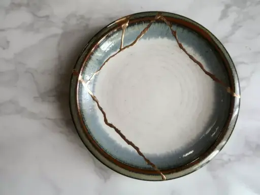 Une assiette ébréchée, réparée avec de l'or, témoigne de la beauté de la résilience.