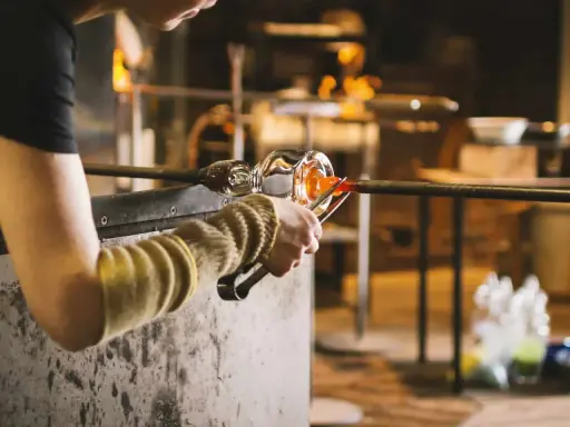 Souffleur de verre travaillant le verre en fusion, un métier qui mérite un bon salaire.