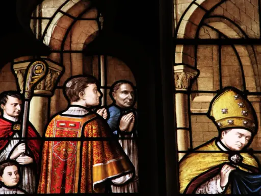 Vitraux de la cathédrale de Nevers : scènes religieuses avec des personnages en habits liturgiques, un évêque coiffé de sa mitre dorée.