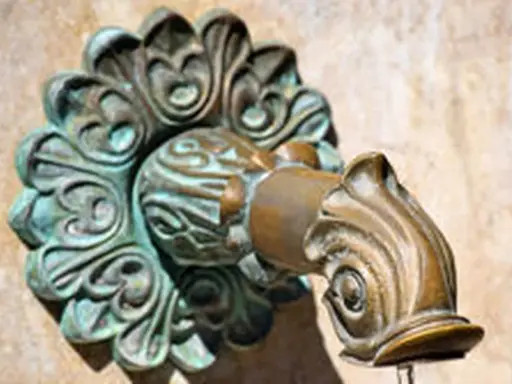 Robinet en laiton orné, avec des traces de vert-de-gris.