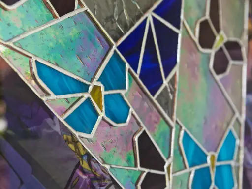 Un vitrail sur mesure aux couleurs vives, avec des motifs de papillons bleus et des éclats irisés.