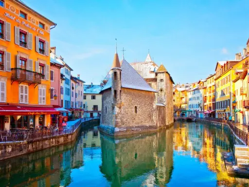 Canal pittoresque à Annecy, avec ses maisons colorées et le Palais de l'Isle. Idéal pour flâner et découvrir l'artisanat local.