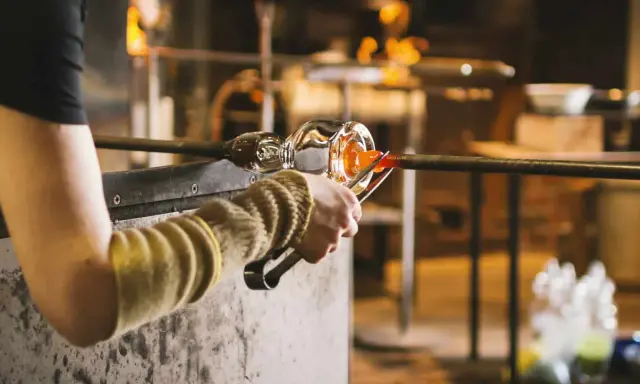 Souffleur de verre travaillant le verre en fusion, un métier qui mérite un bon salaire.