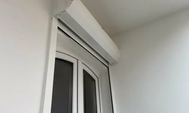 Un imposte blanc est installé au-dessus d'une porte-fenêtre blanche.