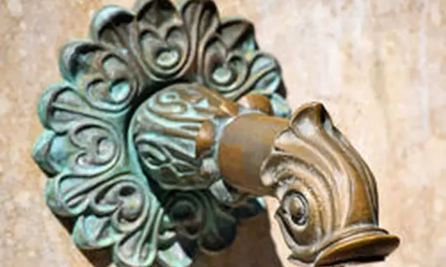 Robinet en laiton orné, avec des traces de vert-de-gris.