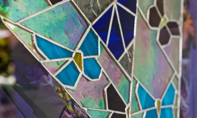 Un vitrail sur mesure aux couleurs vives, avec des motifs de papillons bleus et des éclats irisés.