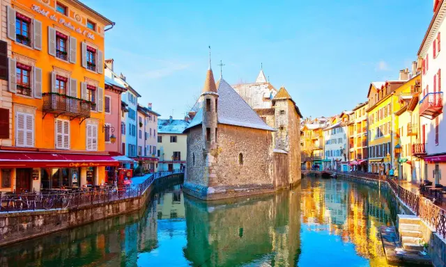 Canal pittoresque à Annecy, avec ses maisons colorées et le Palais de l'Isle. Idéal pour flâner et découvrir l'artisanat local.