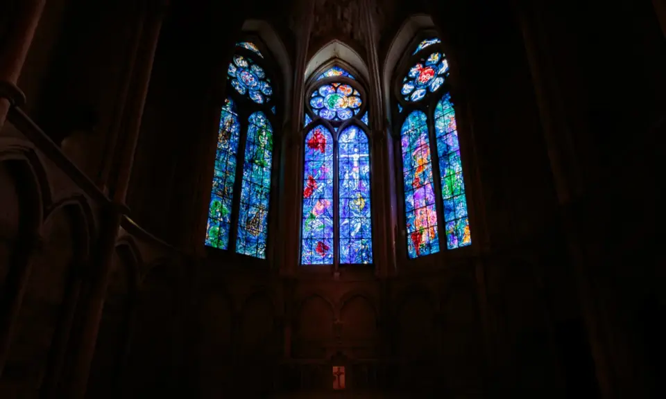 Vitraux de Chagall à Reims, illuminant l'intérieur sombre d'une cathédrale gothique.