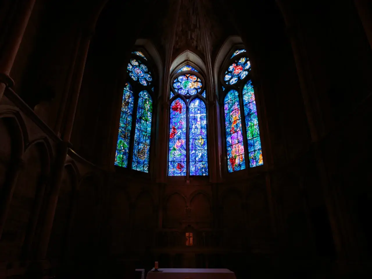 Vitraux de Chagall à Reims, illuminant l'intérieur sombre d'une cathédrale gothique.