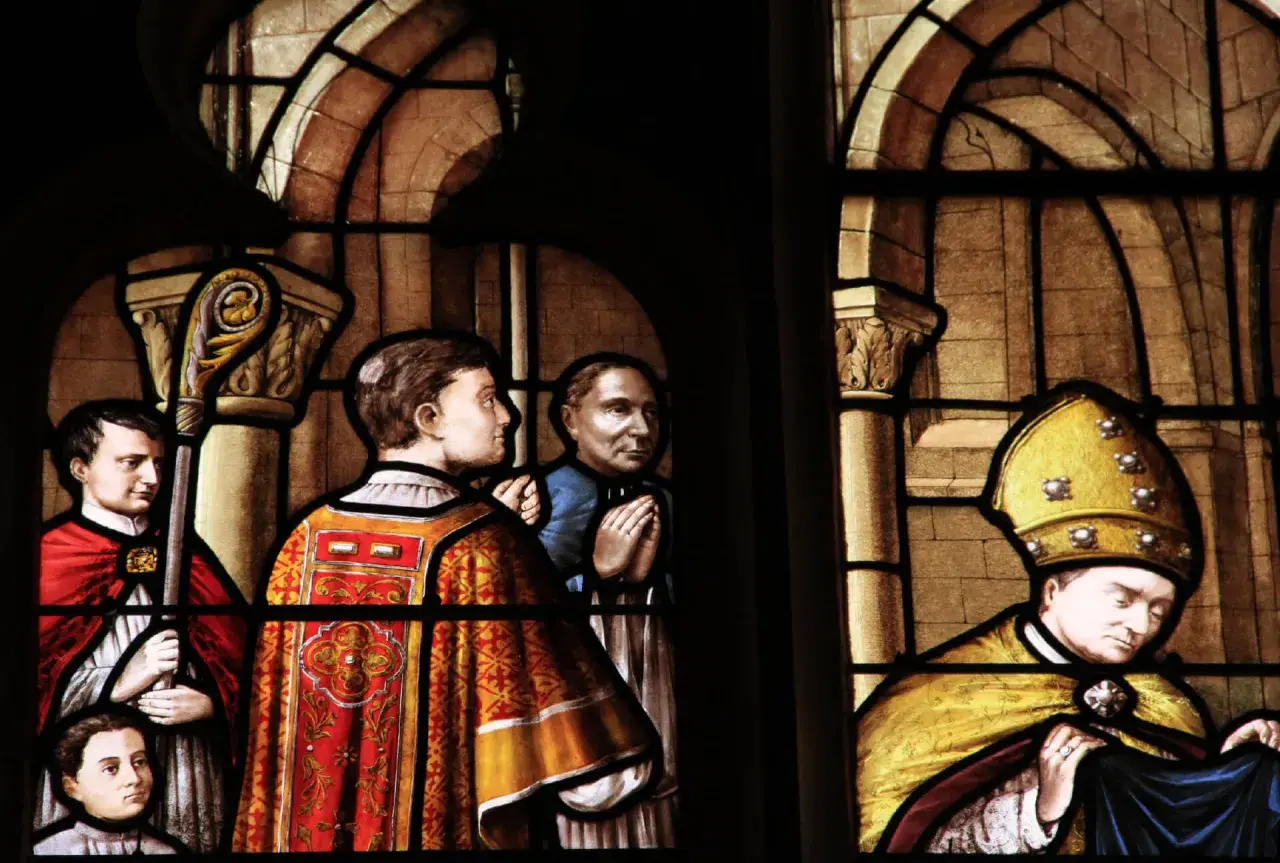 Vitraux de la cathédrale de Nevers : scènes religieuses avec des personnages en habits liturgiques, un évêque coiffé de sa mitre dorée.