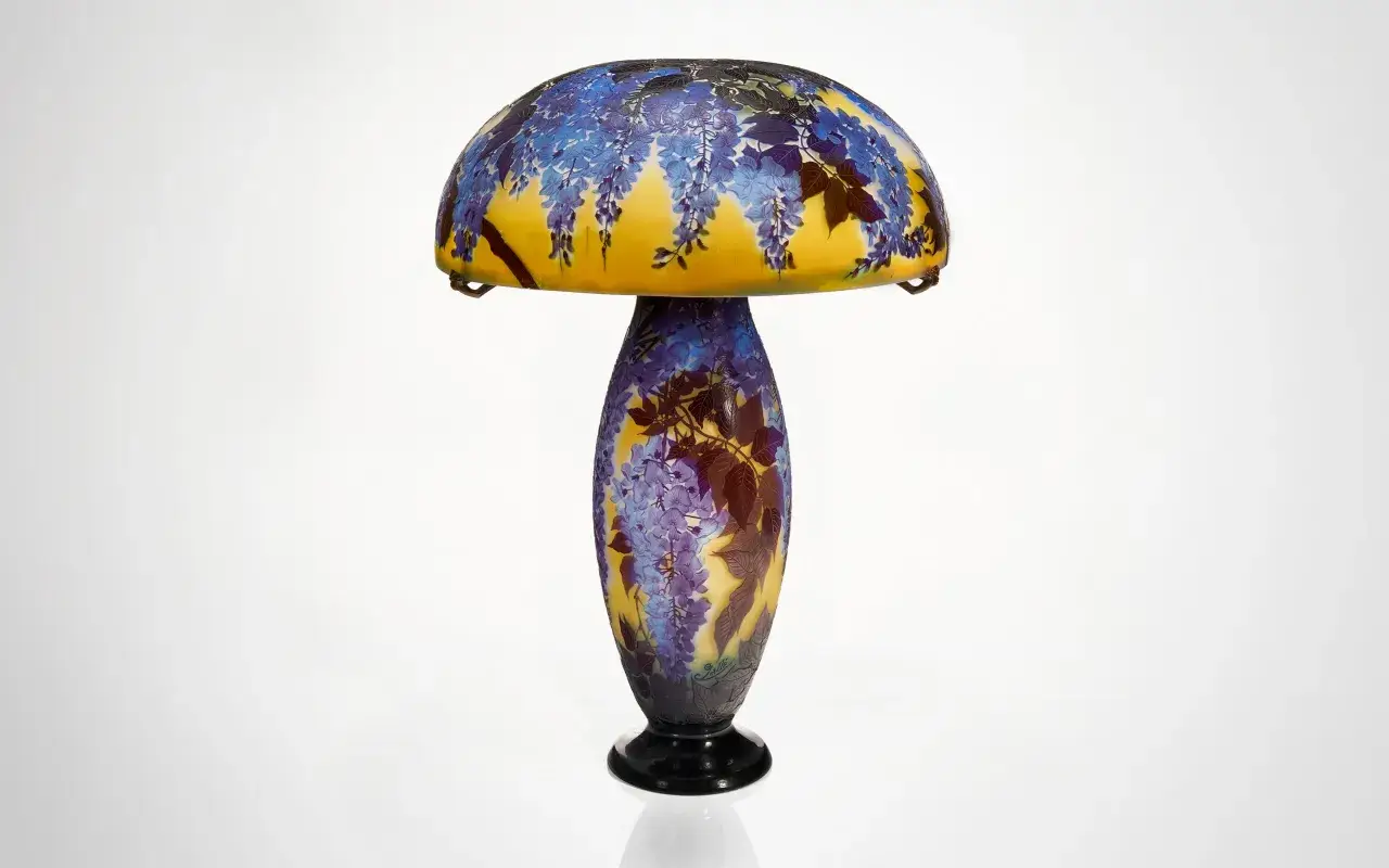 Lampe Art Nouveau d'un artiste verrier, ornée de glycines bleues et de feuilles sur un fond jaune.