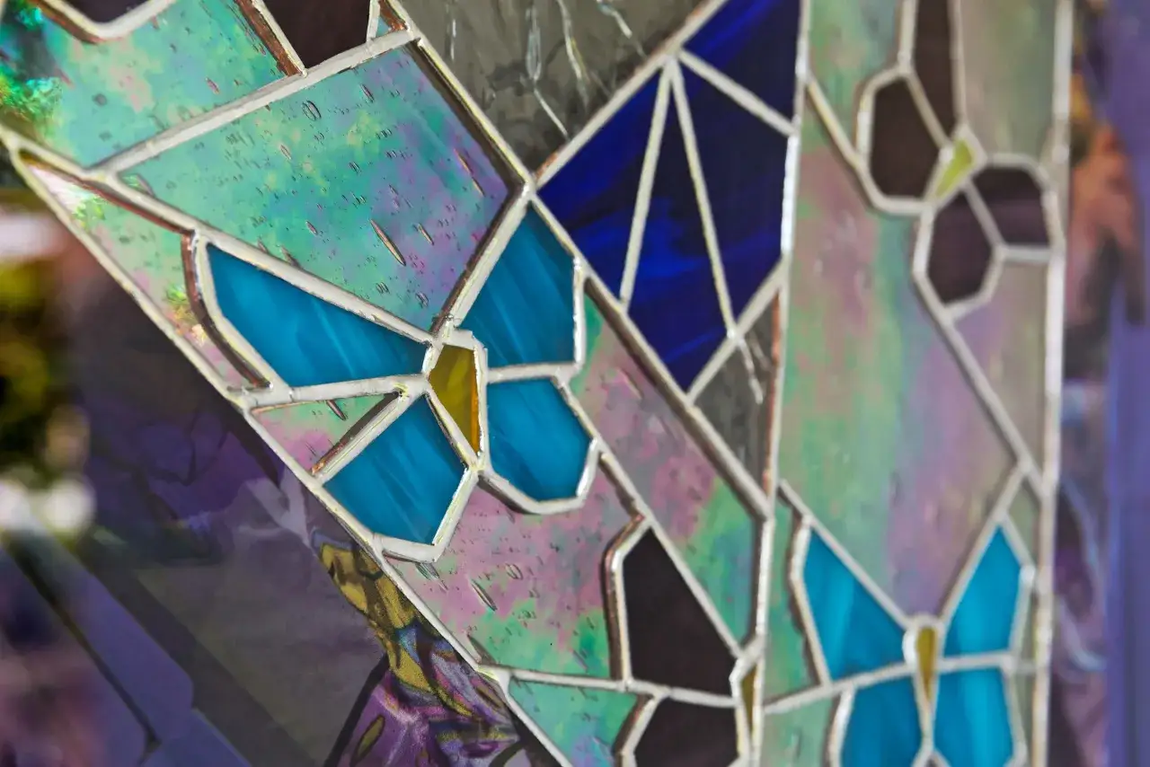 Un vitrail sur mesure aux couleurs iridescentes et bleues, orné de motifs de papillons.