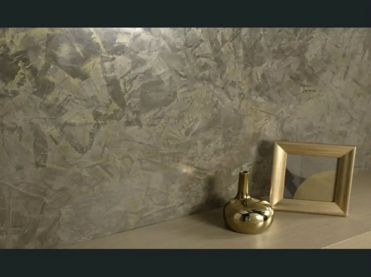 Un mur textur&eacute; avec un dosage patine subtil, rehauss&eacute; par un vase dor&eacute; et un cadre photo.