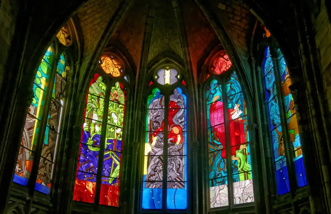 Les vitraux de la cathédrale de Nevers illuminent l'édifice de couleurs vives, racontant des histoires sacrées à travers leurs dessins complexes.