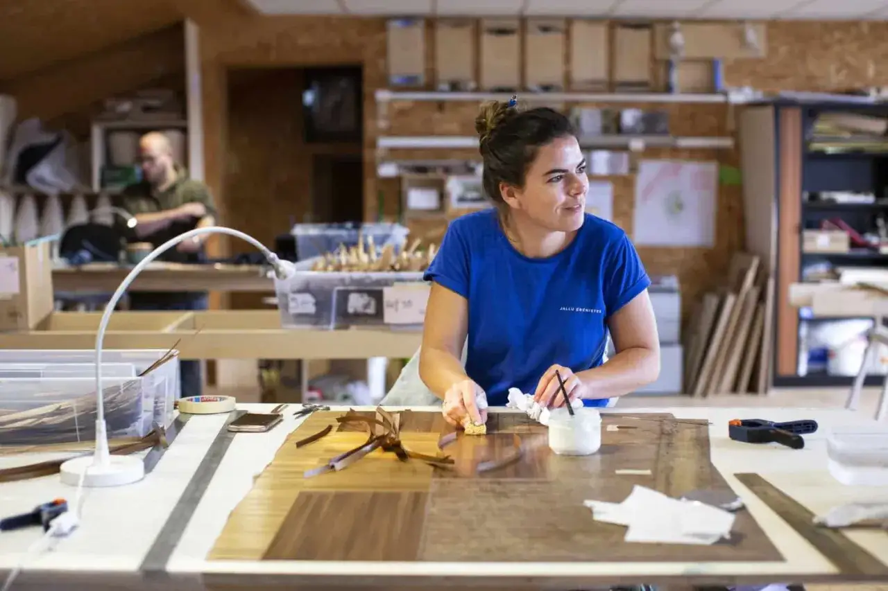 Artisane marqueteuse au travail, un m&eacute;tier d'art qui demande pr&eacute;cision et savoir-faire. Le salaire d'un marqueteur d&eacute;pend de son exp&eacute;rience.