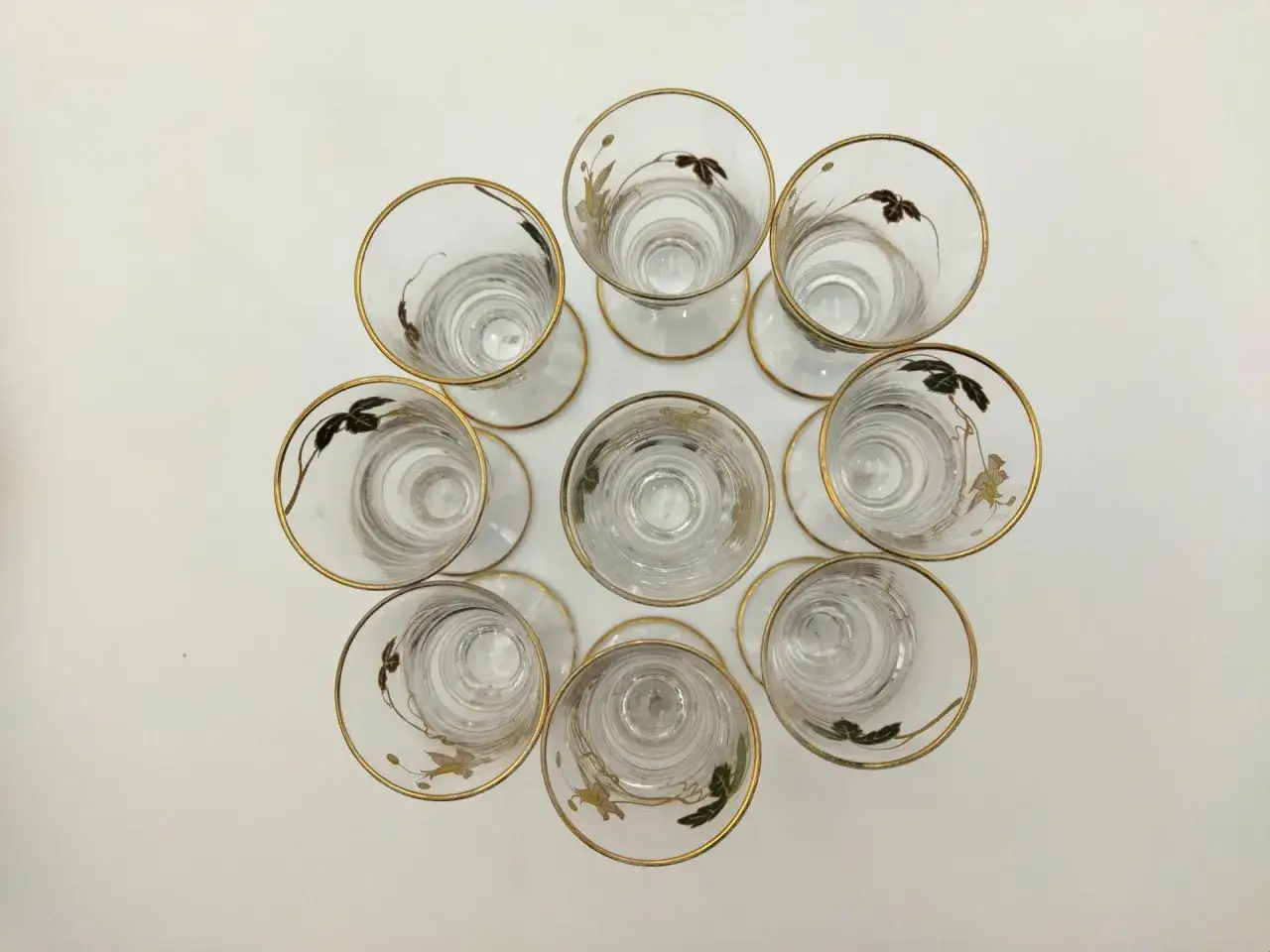 Neuf verres à pied en cristal, bordés d'or, ornés d'un délicat vitrail fleur.