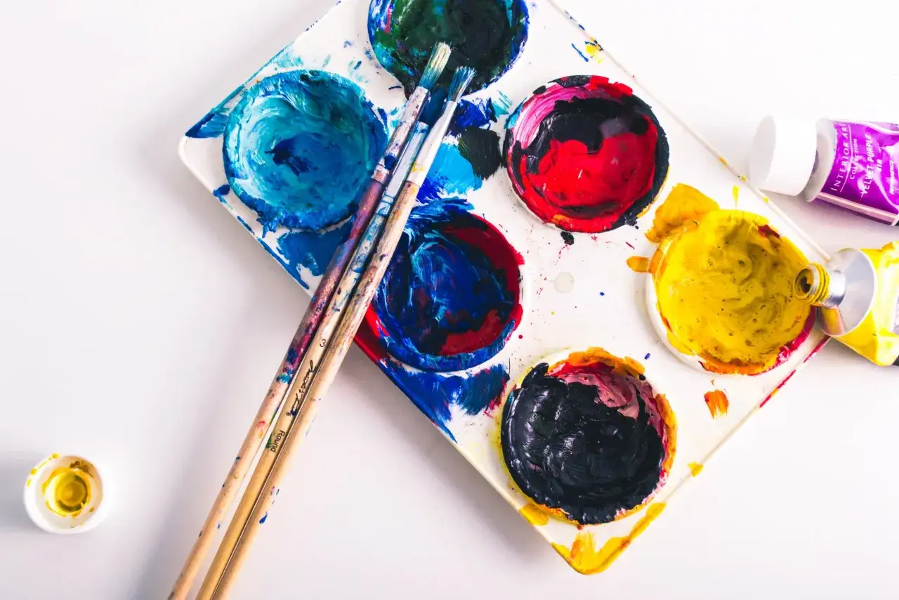 Palette de peinture avec des couleurs vives et des pinceaux, pr&ecirc;te pour une nouvelle technique de peinture.