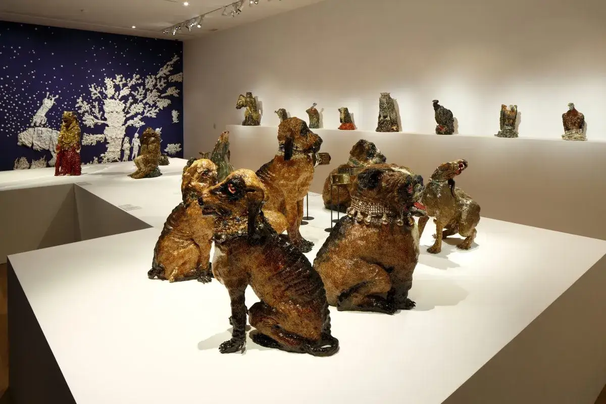 Exposition de sculptures animalières en céramique, œuvres d'un céramiste connu, présentées sur des socles blancs.