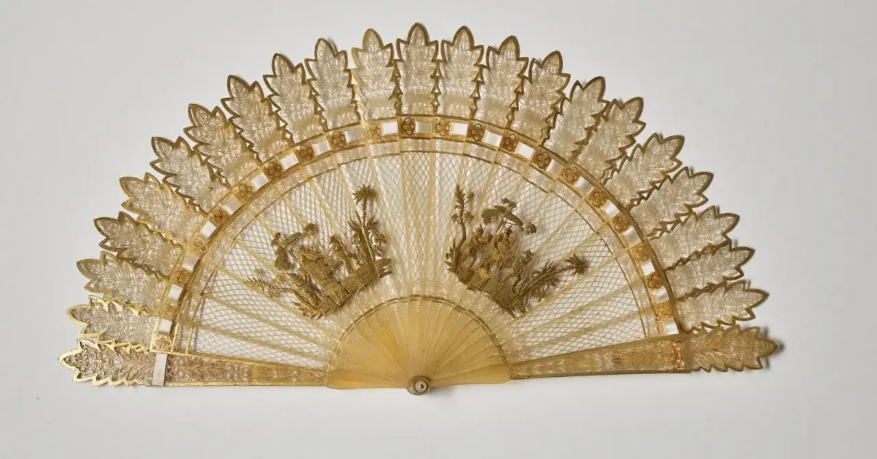 &Eacute;ventail en dentelle d'or, orn&eacute; de sc&egrave;nes dor&eacute;es, t&eacute;moignant du savoir-faire du tabletier m&eacute;tier.