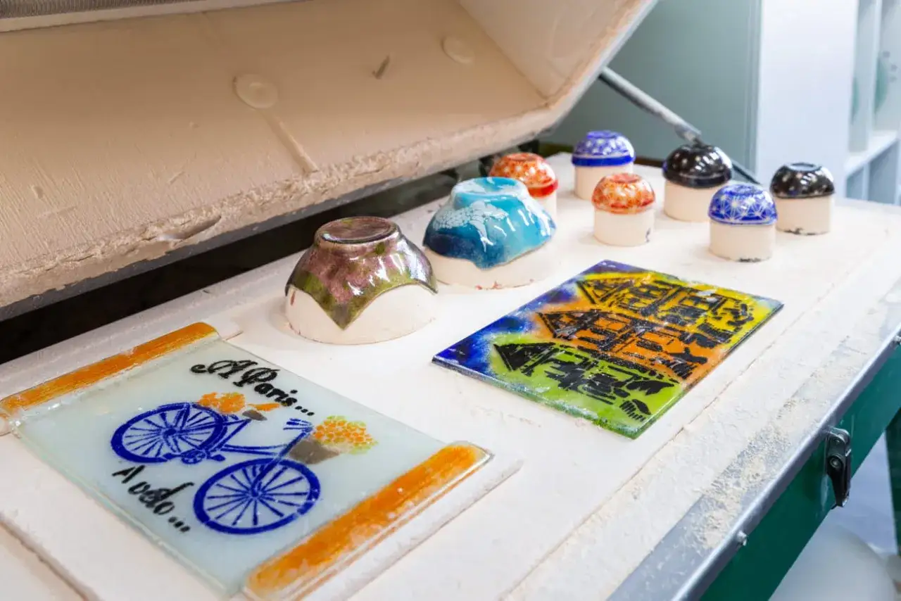 Des cr&eacute;ations en verre color&eacute;, pr&ecirc;tes pour le fusing, attendent dans un four. Une sc&egrave;ne parfaite pour apprendre le fusing et cr&eacute;er des objets uniques.